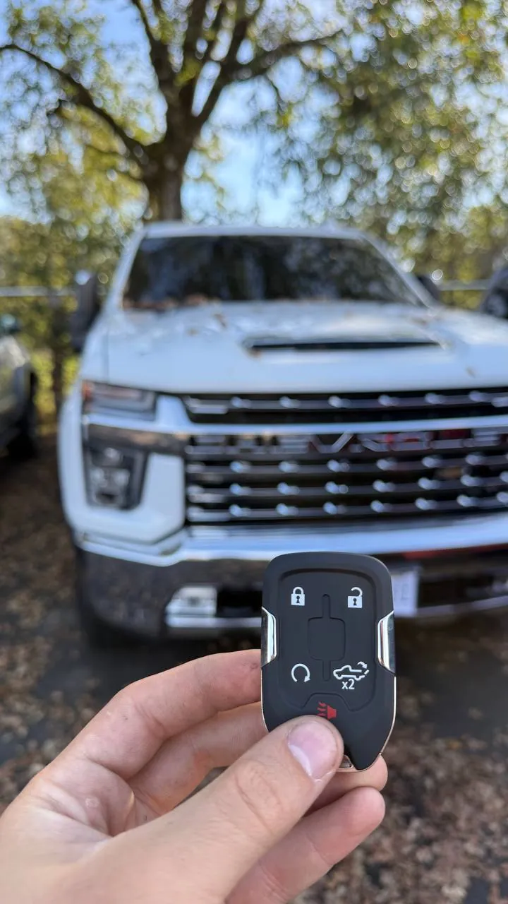 New smart key held in front of a white Chevrolet Silverado HD pickup