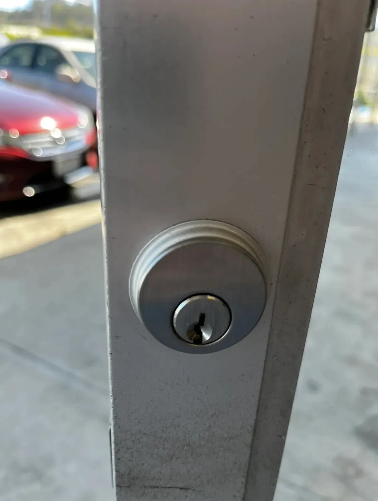 Deadbolt cylinder on the stile of an aluminum storefront door